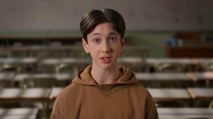 Male student in brown hoodie speaking to the camera