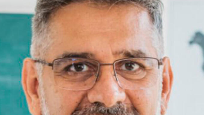 A white male with glasses and salt and pepper hair and beard