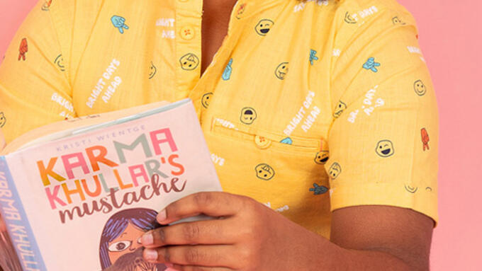 A smiling young child reading a book