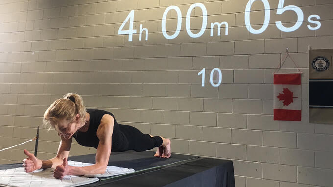 A teacher holds a plank position for over four hours to set a new world record