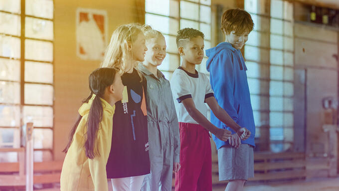 Children standing in a line in a gym