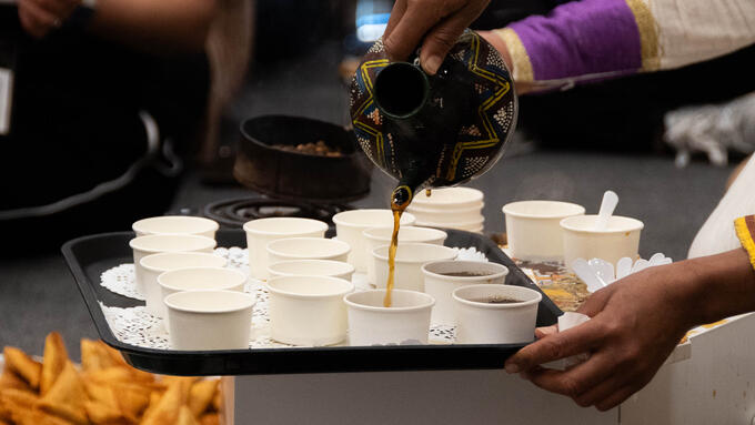 Coffee being poured into small sample paper cups