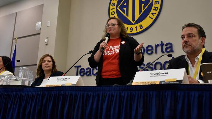 Four NDP candidates sit at table speaking at the Local Communications Officers meeting