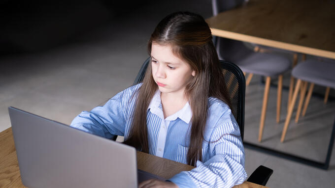 A young girl looks at a computer screen