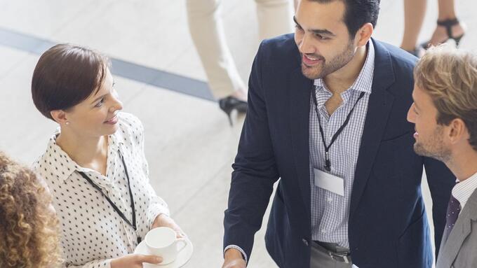 Two men and two women convene in a conference hall
