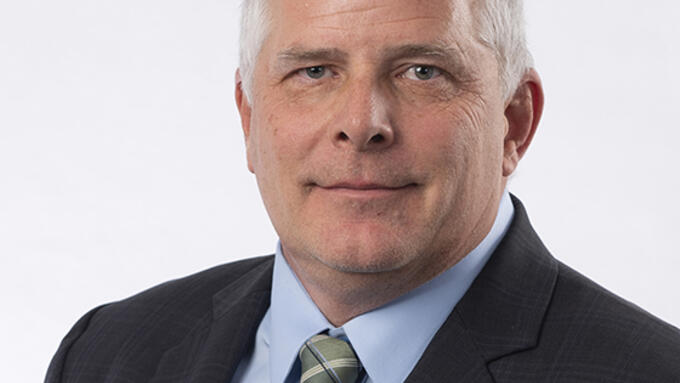 Portrait of grey haired man wearing green tie