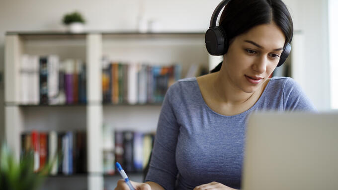 women with headphones on laptop