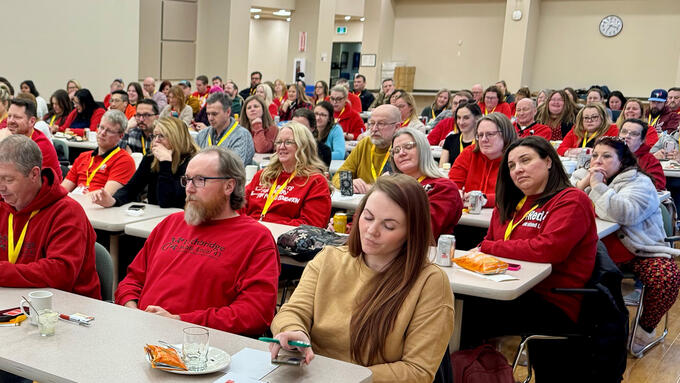 Group wearing red shirts for education seated in a seminar