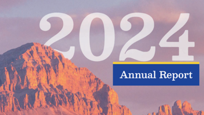 Light blue and pinkish clouds in the bacground of a stoney, brown mountain. The number 2024 and the words Annual Report are in the sky.