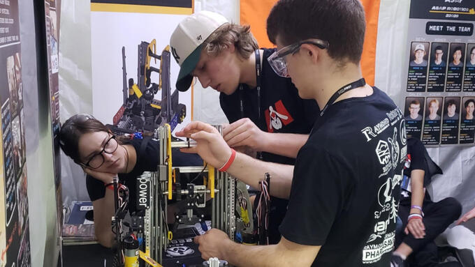 Students working on a robot in a shop