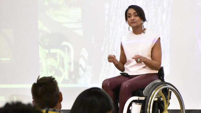 Women in wheelchair speaking in front of conference