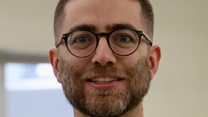 Young man with round glasses and black shirt