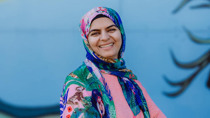 Profile photo of Huma Kashif in front of a local mural in Slave Lake.