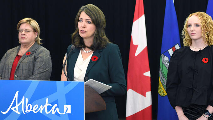 Premiere Smith at a podium speaking about changes to the Education Act