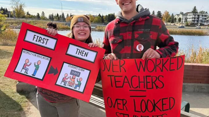 Two people holding signs at a rally