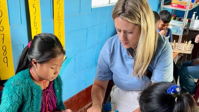 A teacher explains a math lesson to Guatemalan students