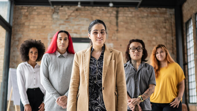 Group of individuals standing in a flying V in a warehouse
