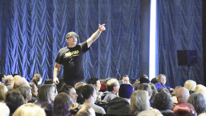 A man speaks to a group of people at a conference