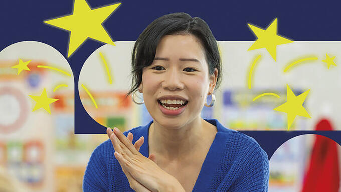 Image of a teacher in front of a bulletin board