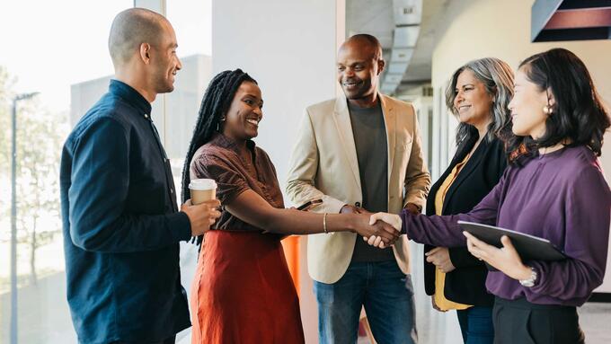 Multiracial group shaking hands and smiling