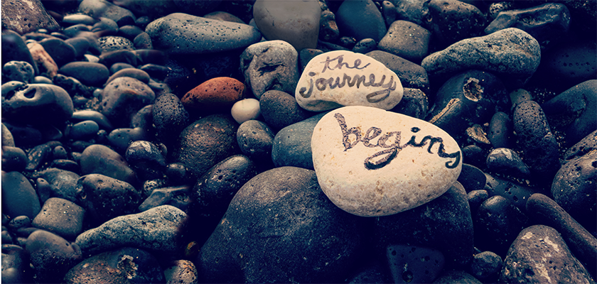 "The Journey Begins" written on rocks