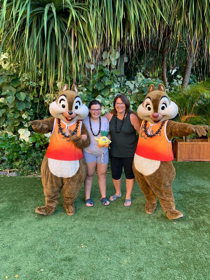 Two women pose with Disney's Chip and Dale characters