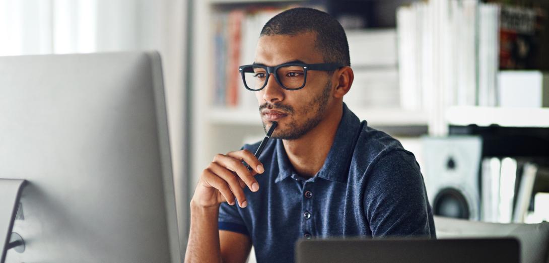 Man in glasses sitting at computer at home