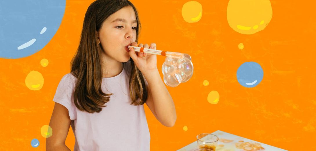 Girl blowing bubbles through a straw