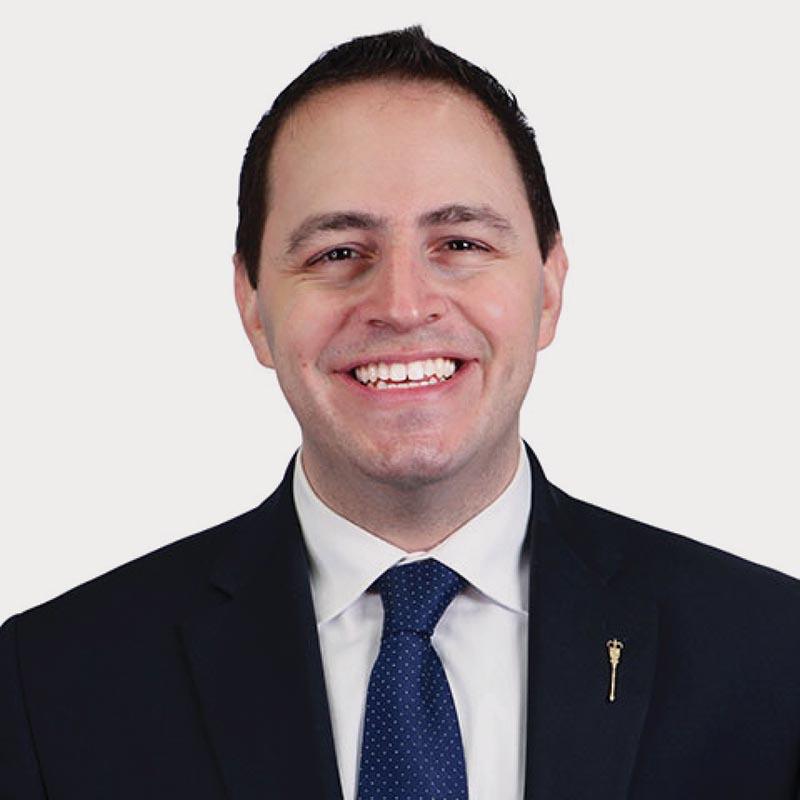 Portrait  of Alberta Education minister wearing a suit and blue tie