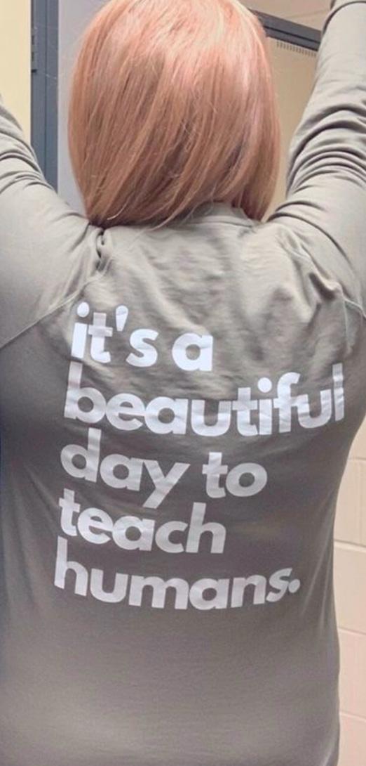 A person's back with text on a shirt that reads, "It's a beautiful day to teach humans."