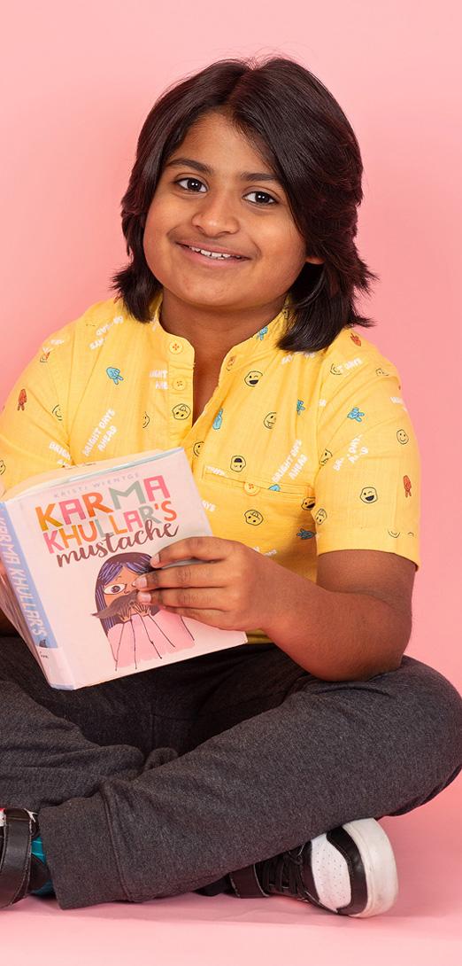 A smiling young child reading a book