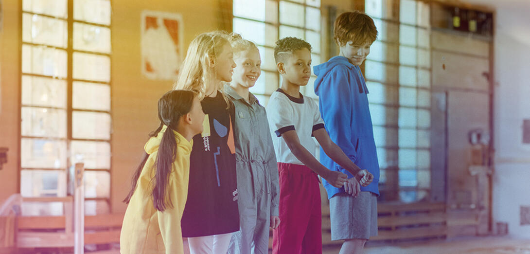 Children standing in a line in a gym