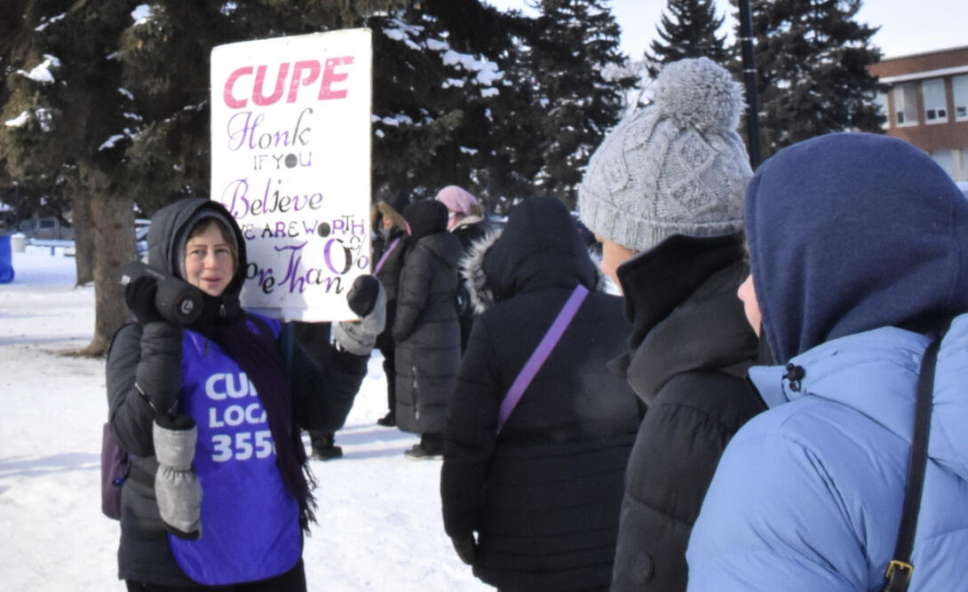 Striking workers hold signs