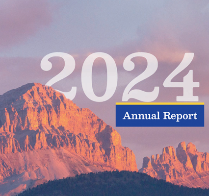 Light blue and pinkish clouds in the bacground of a stoney, brown mountain. The number 2024 and the words Annual Report are in the sky.