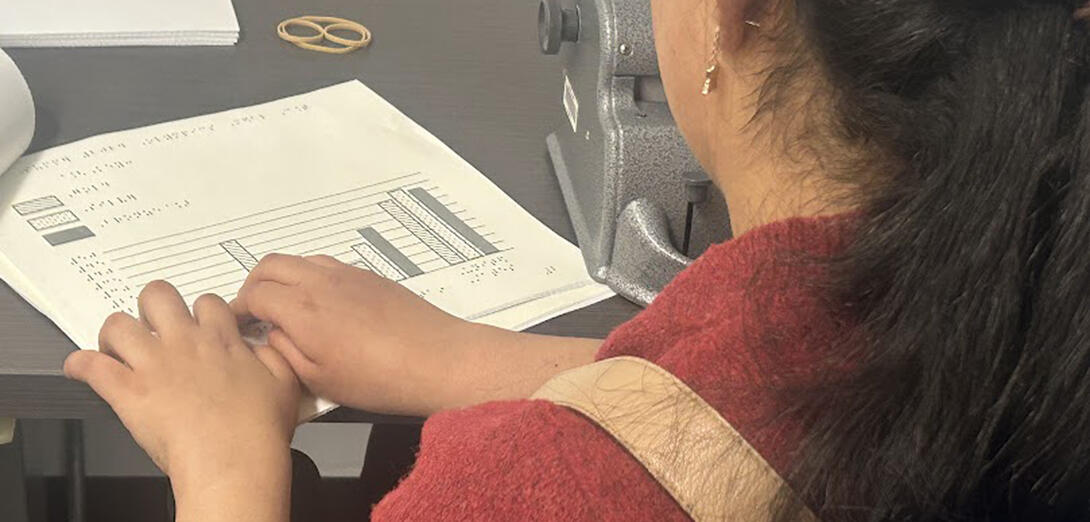 Student at desk reading braille 