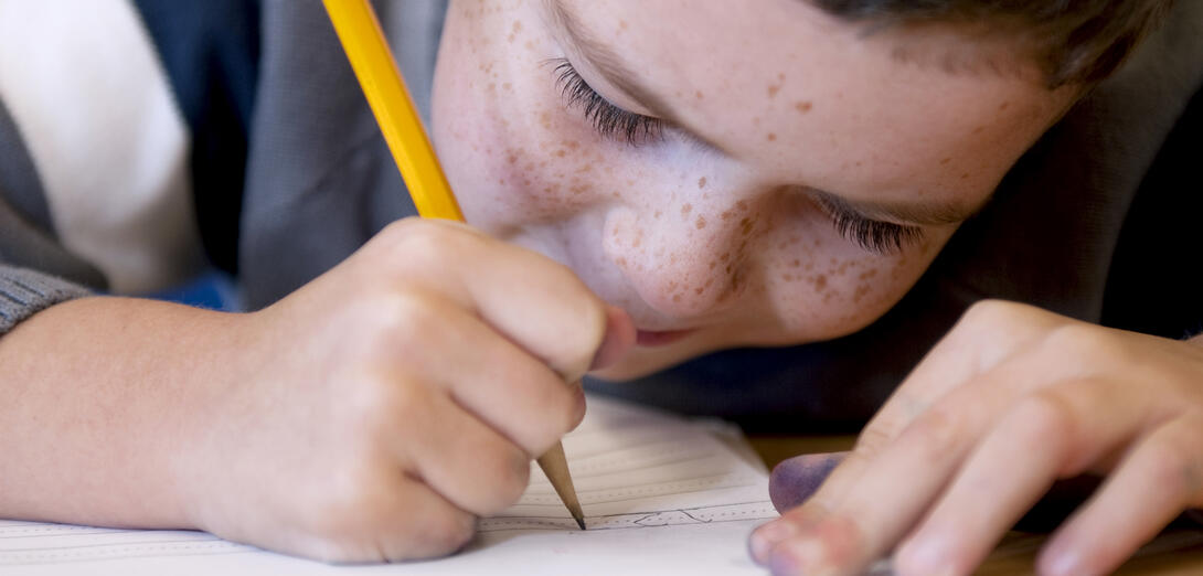 Close up of a child writing an exam