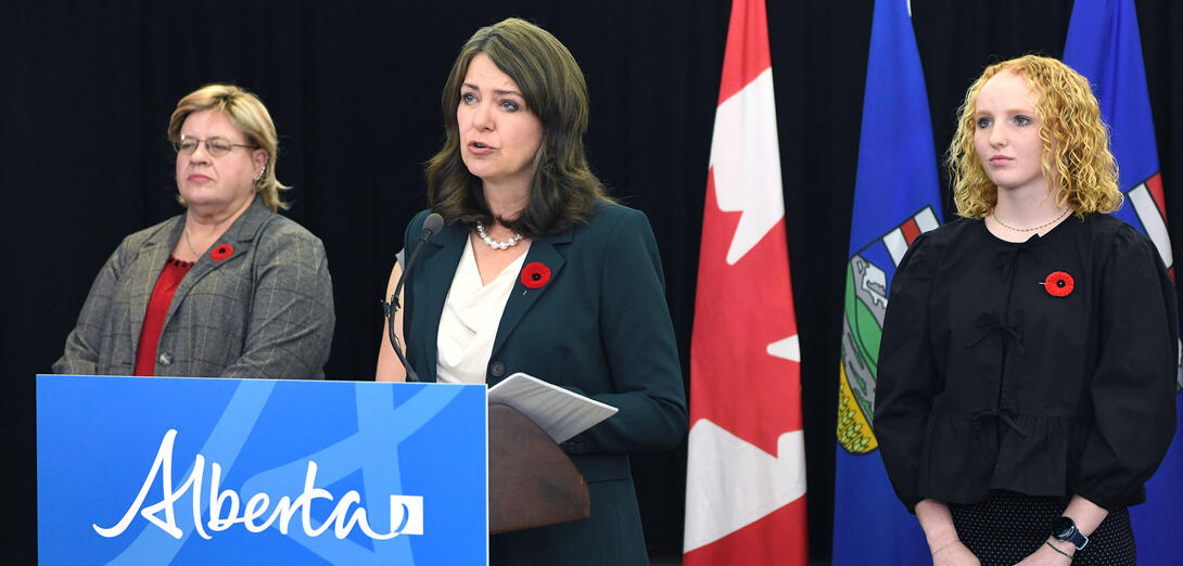 Premiere Smith at a podium speaking about changes to the Education Act