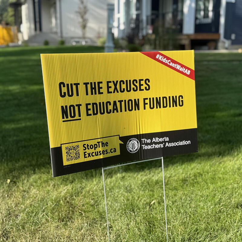 A lawn sign that says "Cut the excuses not education funding"