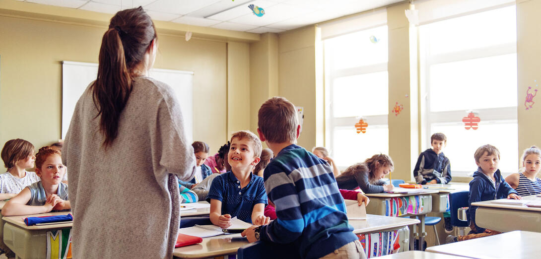 Teacher standing in front of a class of young students